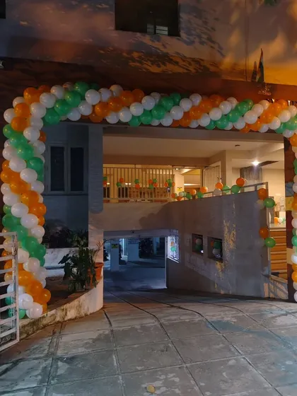 A large tricolor balloon arch at the entrance of a building complex.