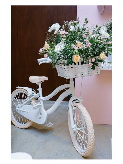 A whimsical prop that adds character to any event. This vintage-style white bicycle with a basket overflowing with flowers was a key decorative element in our Parisian and floral-themed parties.