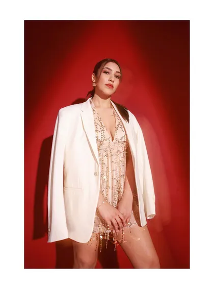 For the bold and fashionable bride, this look pairs a glittering tassel mini dress with a sharp white blazer. It's a perfect example of a high-fashion, modern look for a bachelorette or cocktail party.