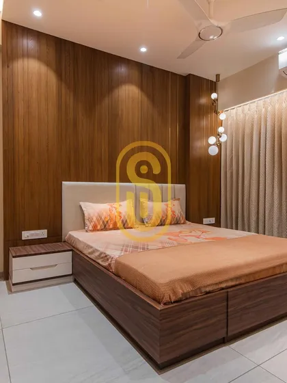 This bedroom design uses warm wood paneling to create a cozy and inviting atmosphere. The globe pendant lights add a modern, sculptural element to the room.