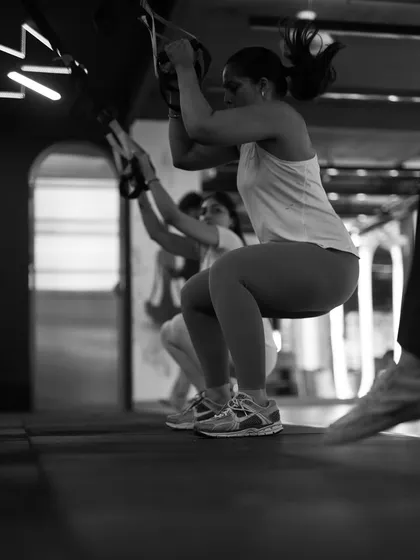 The TRX jump squat is an explosive movement that builds lower body power and cardiovascular endurance. Here you can see the focus and determination it takes to power through the set.