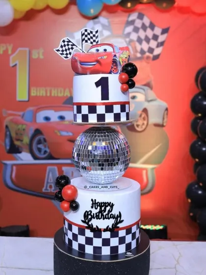 We bring favorite characters to life, like this Lightning McQueen cake for a first birthday. This design combines a disco ball tier with checkered patterns and fondant toppers. Learn how to create fun, themed cakes that will make any child's birthday unforgettable.