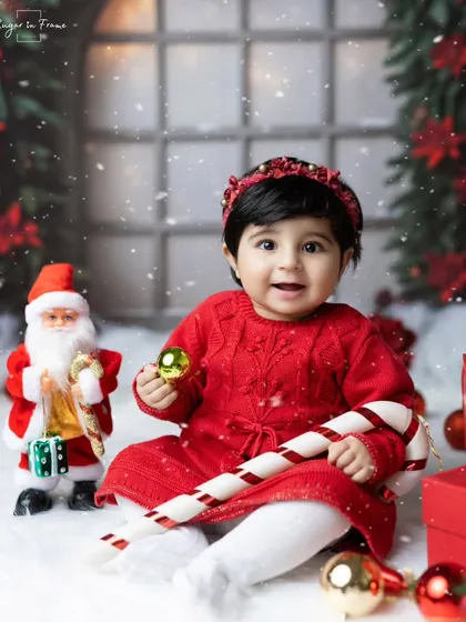 Christmas magic in our studio. This little girl is enjoying the festive setup with Santa, a candy cane, and lots of beautifully wrapped presents.