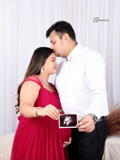 A sweet studio portrait of a couple holding an ultrasound scan, announcing their pregnancy with joy.