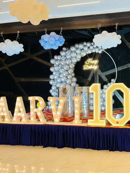 A close-up of the stage decoration for the "sky and clouds" themed event, featuring large light-up marquee letters.