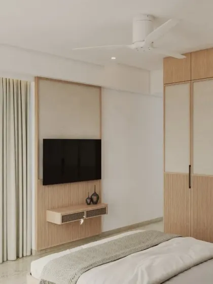 The same Japandi-style bedroom, showing the integrated TV panel and wardrobe. The two-tone design on the wardrobe doors adds a modern touch to the natural wood finish.