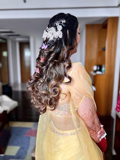 A side view of the haldi hair, showcasing the floral hairpiece and soft curls framing the face.