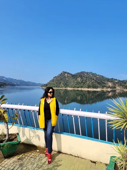 Welcoming the new year with a view. A bright yellow puffer vest adds a pop of color to this winter travel look by the lake.