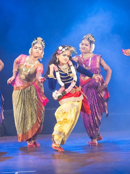 The playful and teasing nature of Krishna's leelas is captured in this interactive scene with the gopis. The vibrant costumes and dynamic poses fill the stage with energy.
