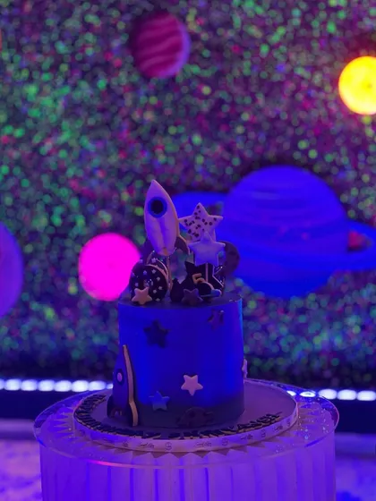 Even the cake is on theme. This space-themed birthday cake with a rocket on top looks perfect against the glowing galaxy wall.