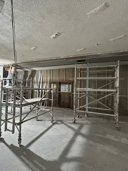 Workers on scaffolding during the ceiling installation at the ZARA Bangalore project. This phase involves extensive MEP work for lighting, HVAC, and fire safety systems.