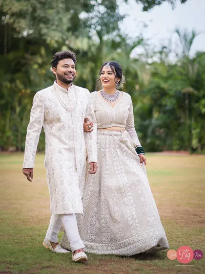 A walk to remember. Aishwarya and Bipinsagar take a stroll in their elegant white wedding attire, sharing a happy, candid moment.
