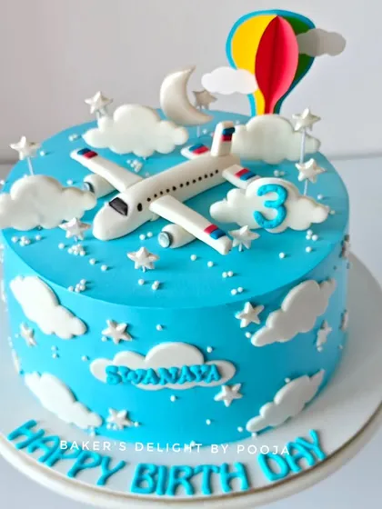 A closer look at the airplane-themed cake, showing the handcrafted fondant plane and other sky-high details.