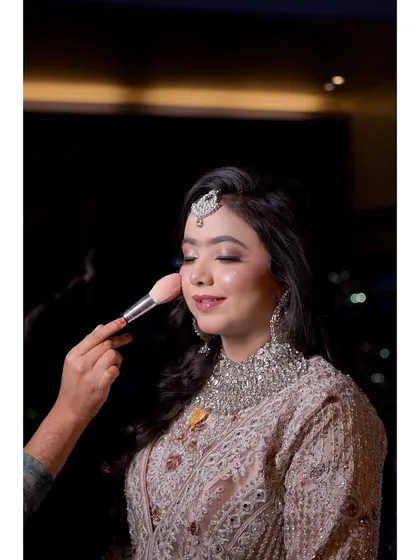 A behind-the-scenes moment, adding the final touch of blush. This is part of the process of creating that perfect, long-lasting glow.