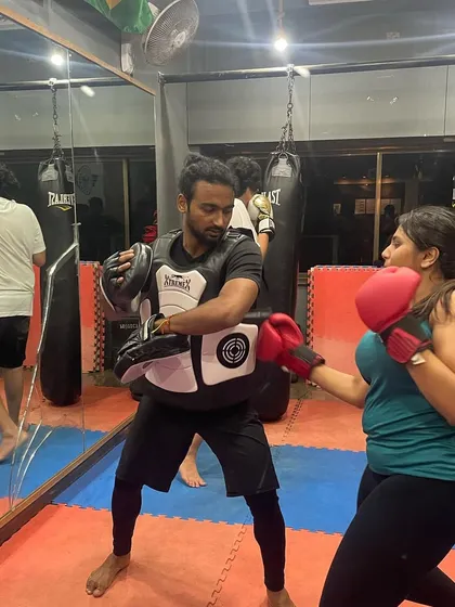 Learning to target the body is key for self-defense. Here, a student practices body shots on my chest guard, a drill that builds power and toughness.