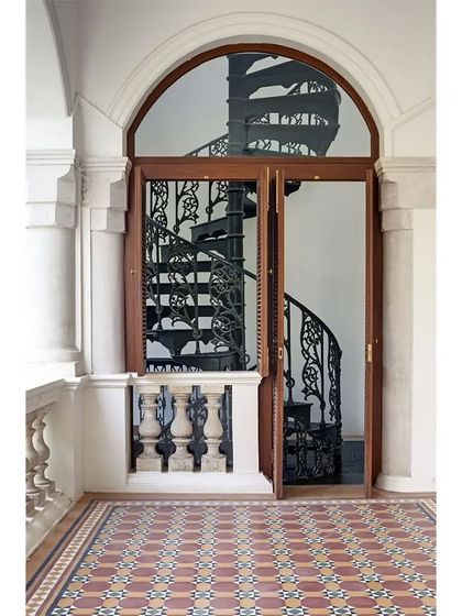 A detail from the Heritage House at the Kasturbhai Lalbhai Gallery. Our conservation work involved carefully restoring original features like this ornate spiral staircase and patterned tile floor, preserving the residential ambiance of the historic home.