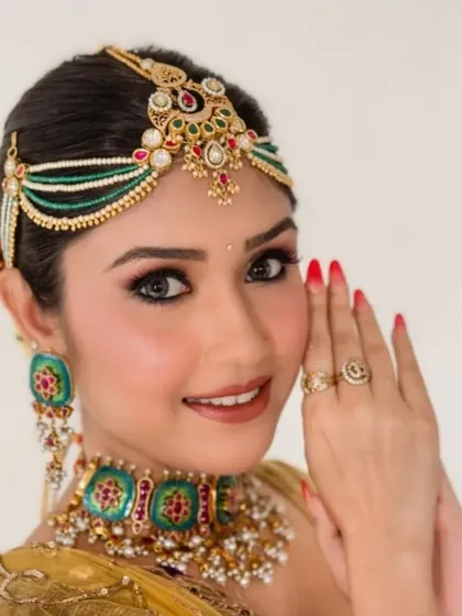 For this traditional look, I created a classic bun and decorated it with colorful floral accessories. The hairstyle perfectly complements the client's vibrant outfit and traditional jewelry.