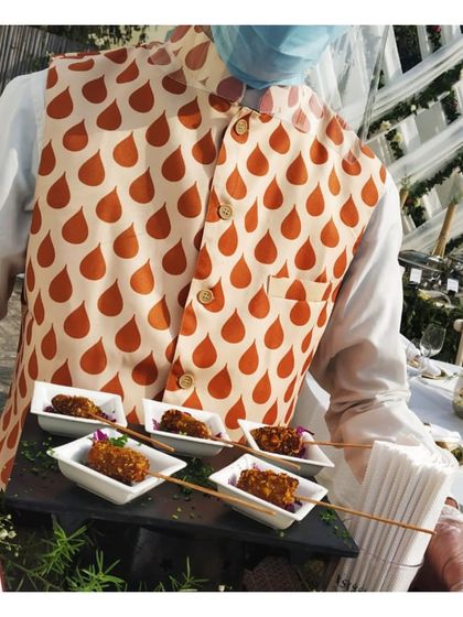 Skewered appetizers being presented by our server. The uniform and stylish waistcoat worn by our staff is part of our cohesive and professional brand identity.