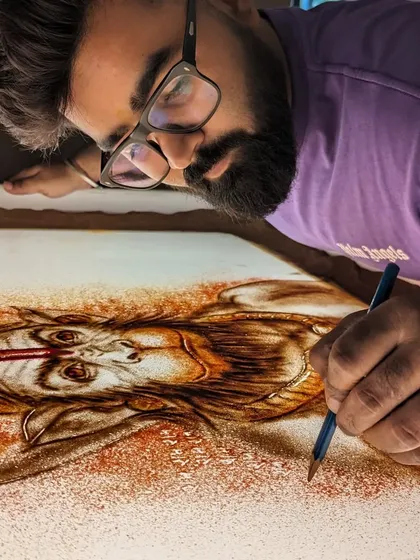 A close-up shot of me meticulously crafting the Hanuman ji sand art.