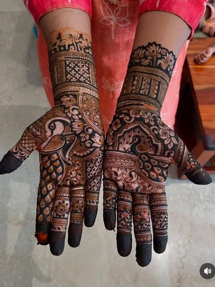 A striking design with heavy use of dark henna to create contrast. It features peacocks, elephants, and lotus flowers for a rich, traditional look.
