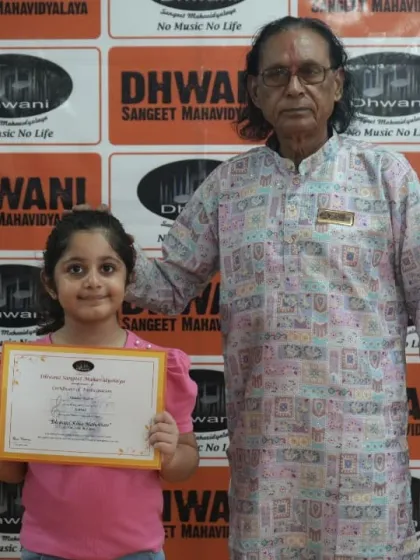 A student receives her award from a senior guru, a moment of honor and inspiration.