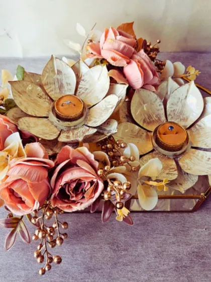This unique ring platter is designed with two large, golden lotus flowers to hold the rings. The rustic floral arrangement around it creates a beautiful, earthy aesthetic for your engagement ceremony.
