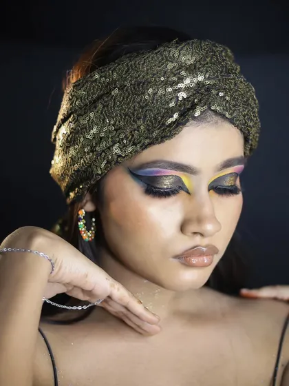 An Egyptian-inspired glamour look, with a dramatic, colorful winged eyeliner and a sequined headband.