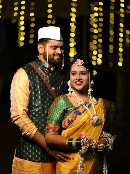 A classic Maharashtrian Haldi portrait. The bride is adorned in a custom floral set featuring pink and yellow flowers, complete with a traditional mundavalya for an authentic touch.