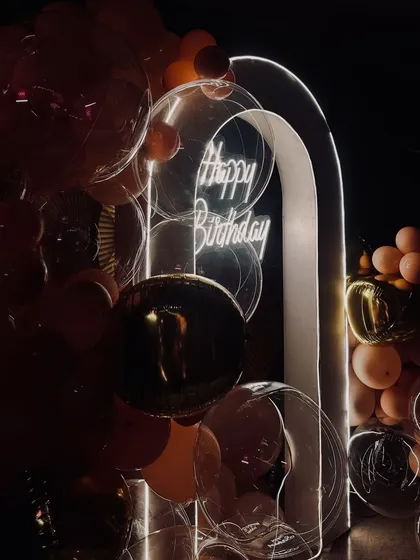 This angle shows how the mix of clear, gold, and peach balloons adds depth and texture to the birthday backdrop, creating a sophisticated yet fun party corner.