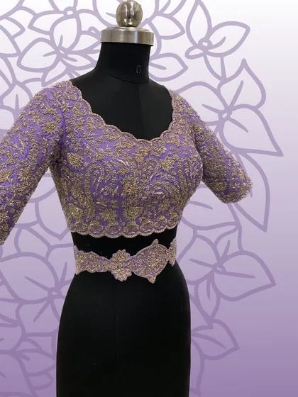 The lavender embroidered blouse and matching belt shown on a mannequin, showcasing the complete set.