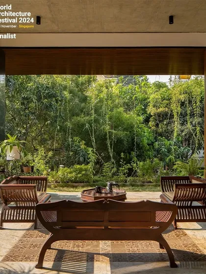 This covered patio demonstrates how I design seamless transitions between indoor and outdoor spaces. The living room opens directly onto this seating area, which is nestled against a backdrop of lush bamboo, creating a tranquil retreat that feels both sheltered and completely open to nature.