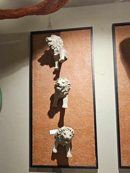 A unique wall art piece featuring a series of lion heads, adding a touch of regal character.