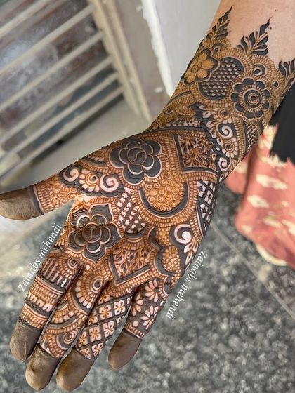 The full palm view of a semi-bridal design, with a mix of bold and fine lines.