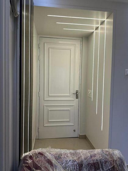 An entryway featuring modern linear lighting that flows from the wall to the ceiling. This creates a dramatic and welcoming first impression, guiding the eye into the home.