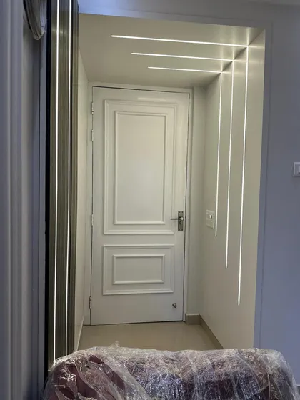 An innovative use of profile lighting to create a graphic feature in a hallway. The clean lines of light run along the wall and across the ceiling, guiding the eye and adding a contemporary architectural element to the space.