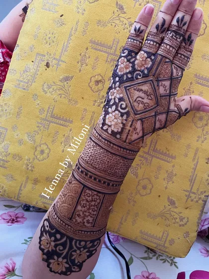 A full-arm mehendi for a baby shower. The design incorporates the words "Baby Shower" in a geometric pattern, along with other floral and traditional elements.
