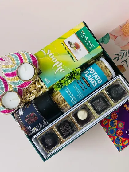 A tilted view of the second floral box option, highlighting the assortment of gourmet chocolates and the beautifully crafted T-light holders.