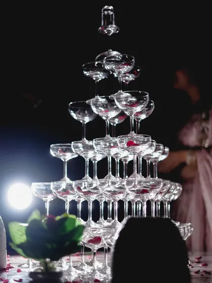 A classic shot of a champagne tower, a symbol of celebration at engagement and reception parties.