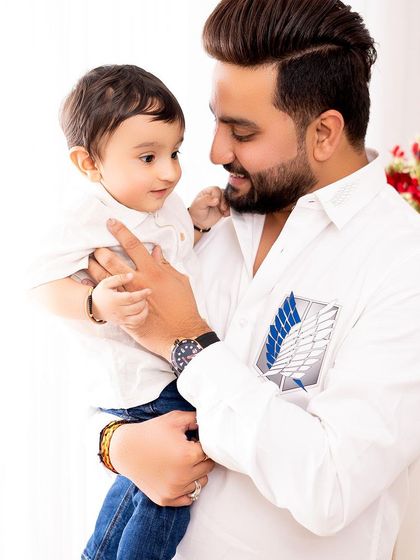 A candid and sweet moment between a father and his son. The simple white shirts keep the focus on their interaction and expressions.
