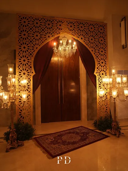 The grand Moroccan-Sufi entrance, featuring a stunning jaali arch, crystal chandelier, and rich red drapes. This sets an immediate tone of luxury and thematic immersion.