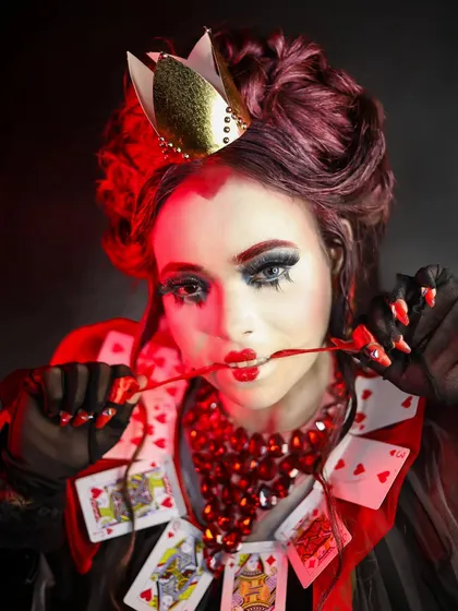 A powerful, moody portrait of the Queen of Hearts, showcasing the character's fierce personality through makeup and expression.