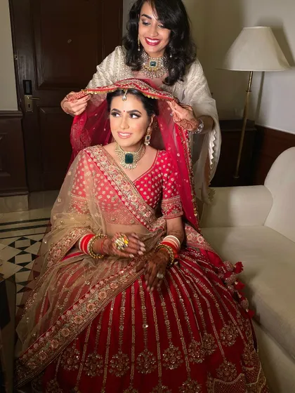 A sister's love is a special part of any wedding. Here, the bride's classic makeup look, with its defined eyes and radiant skin, is the perfect backdrop for this sweet moment.