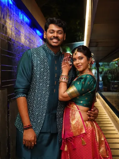 A happy portrait of the couple, with the bride-to-be showing off her henna-adorned hand.