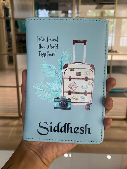 A close-up of the "Let's Travel The World Together!" passport cover, personalized with the name 'Siddhesh'. The design is perfect for a travel-loving couple.