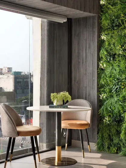 Another view of our office project, showcasing the conversation nook with a vertical garden. The juxtaposition of natural elements with modern furniture creates a balanced and refreshing workspace.