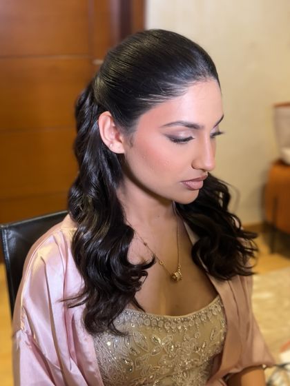 A side profile showing the sleek top and wavy lengths of this half-up hairstyle.