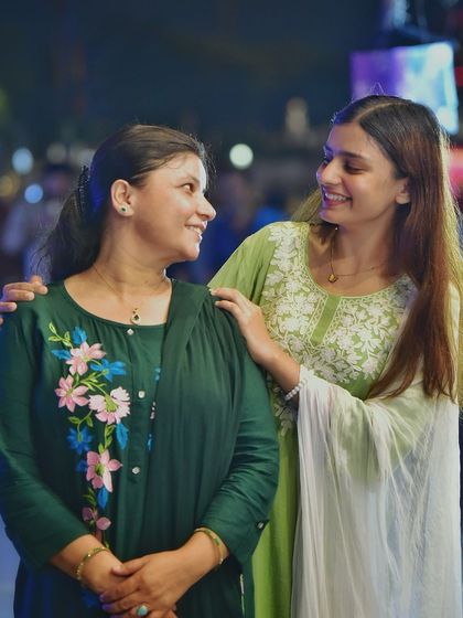 A sweet, candid moment between a mother and daughter. Their shared look and smiles create a powerful emotional connection in this beautiful night portrait.