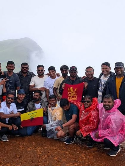 A large group photo from a Nethravathi trek, with some members proudly holding the Karnataka flag.