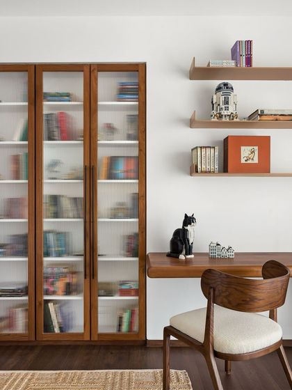 The home office and library in the West Coast Residence, designed with custom teak shelving and a floating desk to be both beautiful and practical.