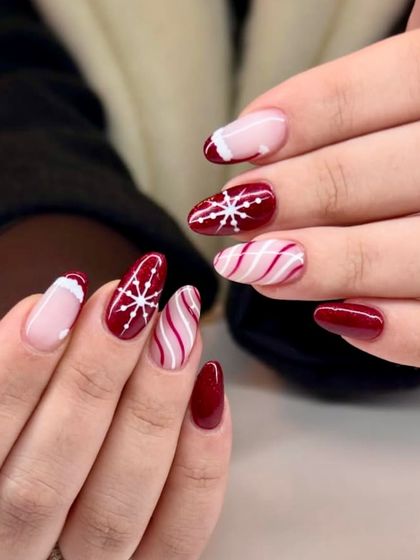 Snowflakes, candy stripes, and zero subtlety. This winter nail set is done right, with a deep red base, crisp white details, and a fun mix of patterns.
